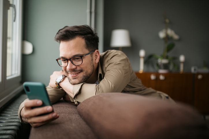 mężczyzna w okularach korzysta z telefonu