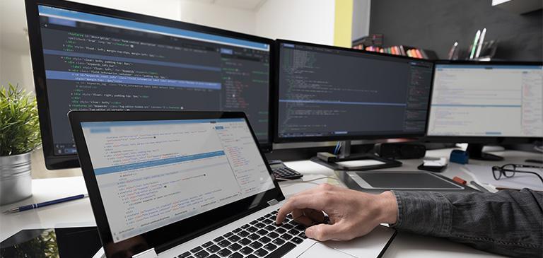 laptop i dwa ekrany komputerowe